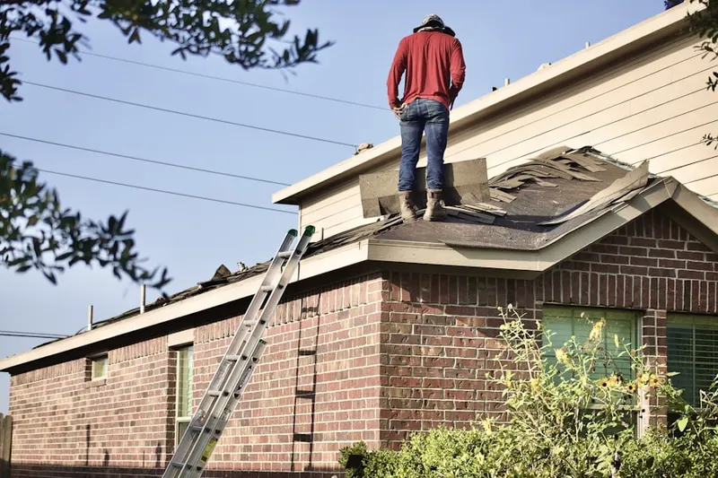 Professional roofer working on a residential roof in Henrietta